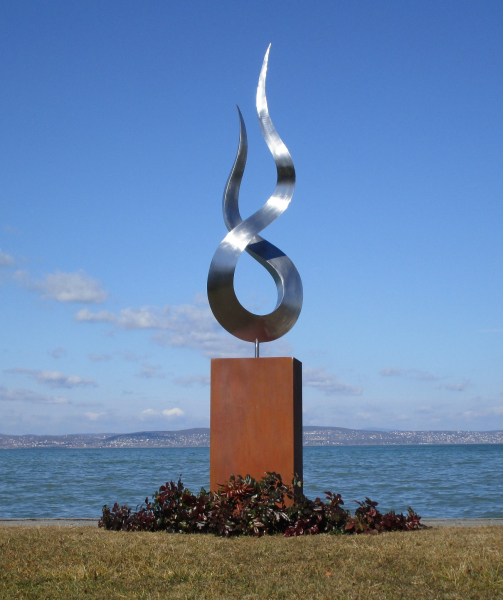 Stainless steel flame artwork on rusty column